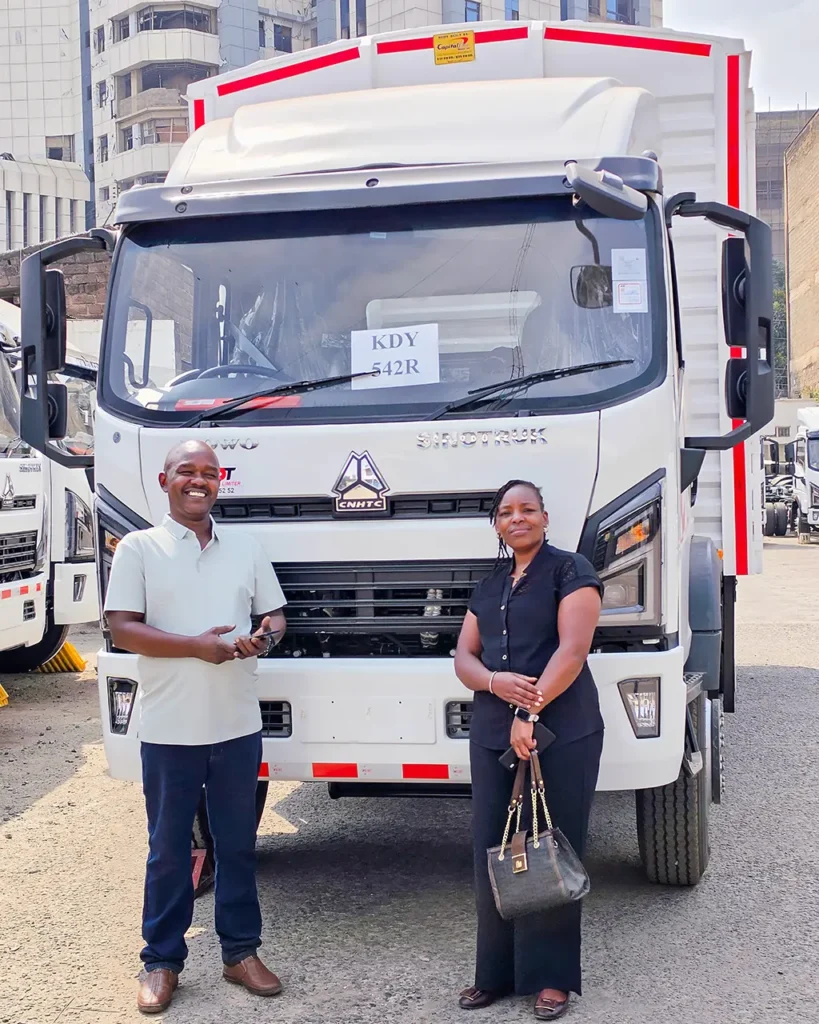 A man and a woman stand in front of a new white Sinotruk Howo M3 5200MM with a closed box body and red reflective striping at the BestVet Agro Concepts handover in a Nairobi truck yard | Patison Sinotruk Howo
