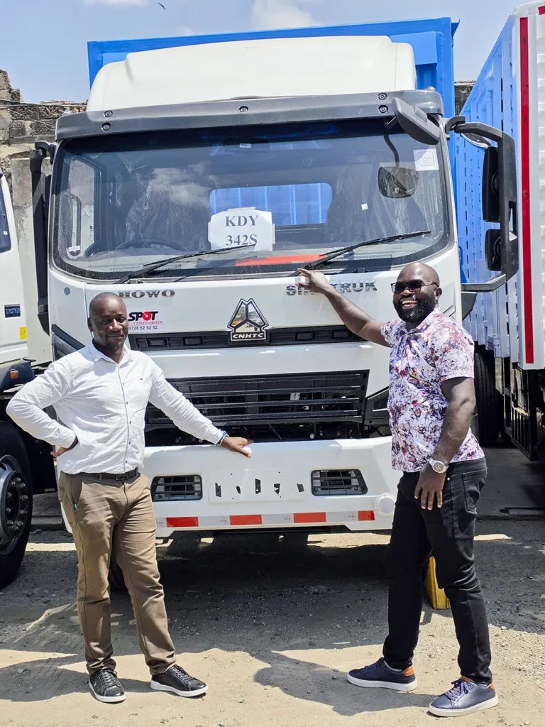 Two men stand either side of a new white Sinotruk Howo M3 Rigid 5200MM with a blue high-sided body at the Dimmer Enterprises Limited handover | Patison Sinotruk Howo