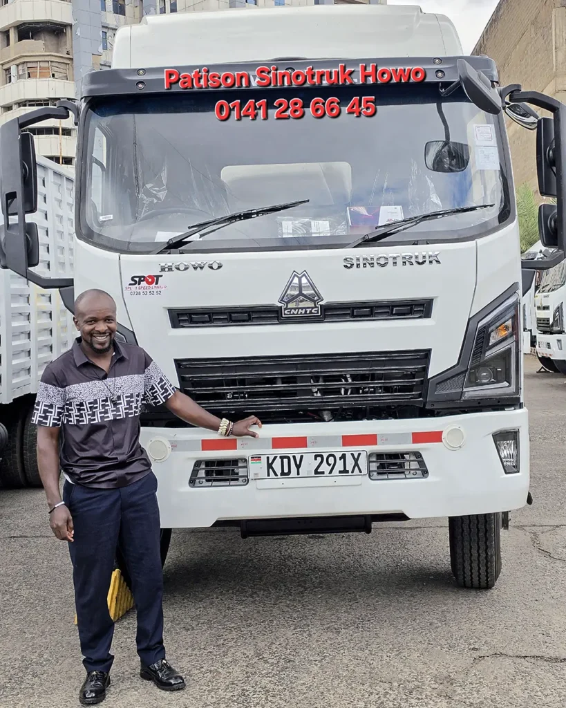 Handover of a new white Sinotruk Howo M3 Rigid 5200MM, registration KDY 291X, to Kagwe Concept Logistics at the Patison Sinotruk Howo yard in Nairobi - a smiling man rests his hand on the front of the brand-new truck, with more Howo trucks parked behind him